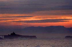 biarritz sunset with the Rocher de la Vierge in front of the mountains in Spain